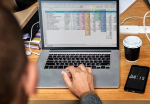 Consultant analysant un tableau budgétaire sur ordinateur dans le cadre de la préparation d'un dossier de demande de subvention.