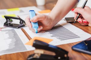 Deux personnes analysent des graphiques et des documents financiers lors de la préparation d’un projet d’investissement.